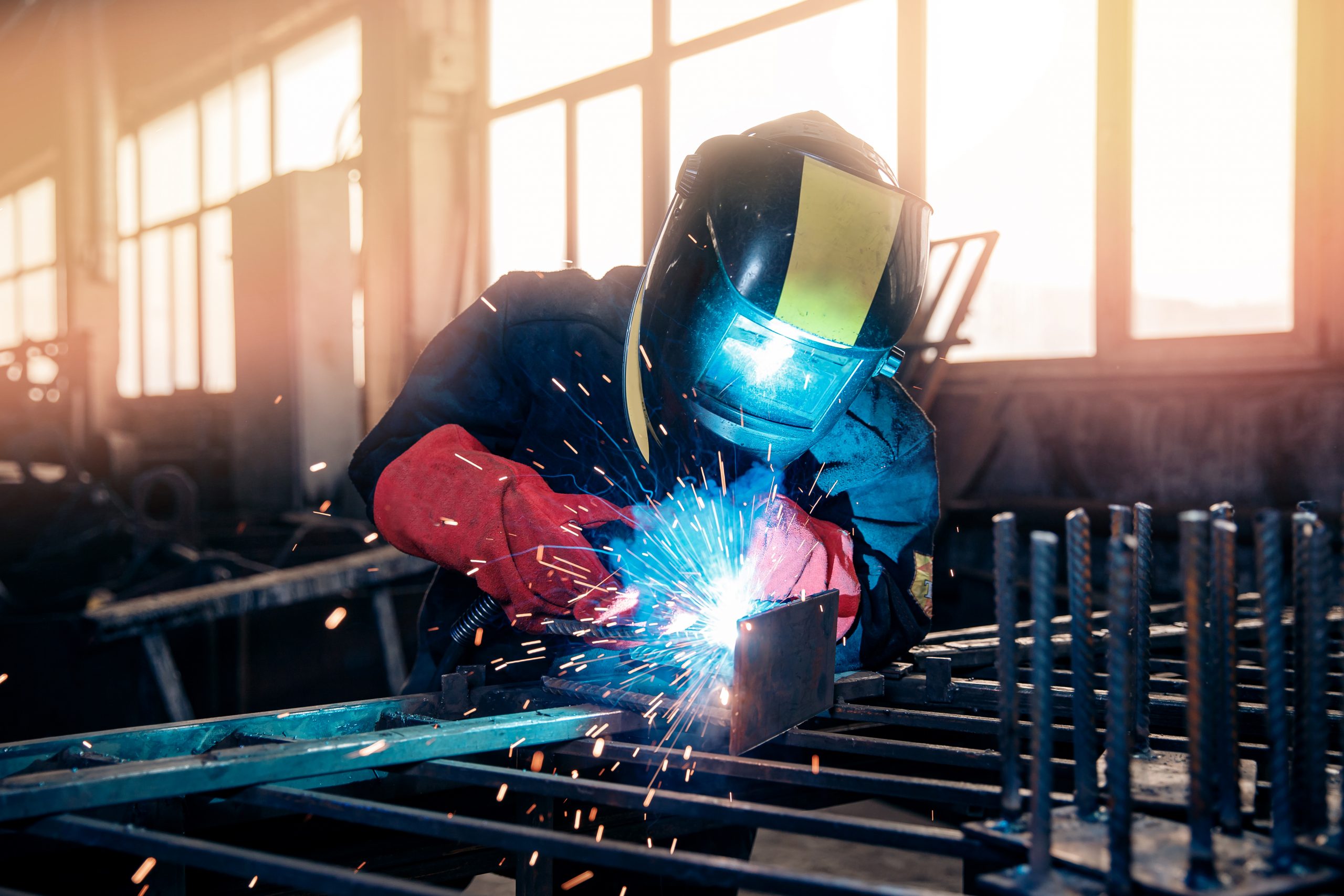 Factory industry worker welder in protective uniform with mask on workplace metalwork